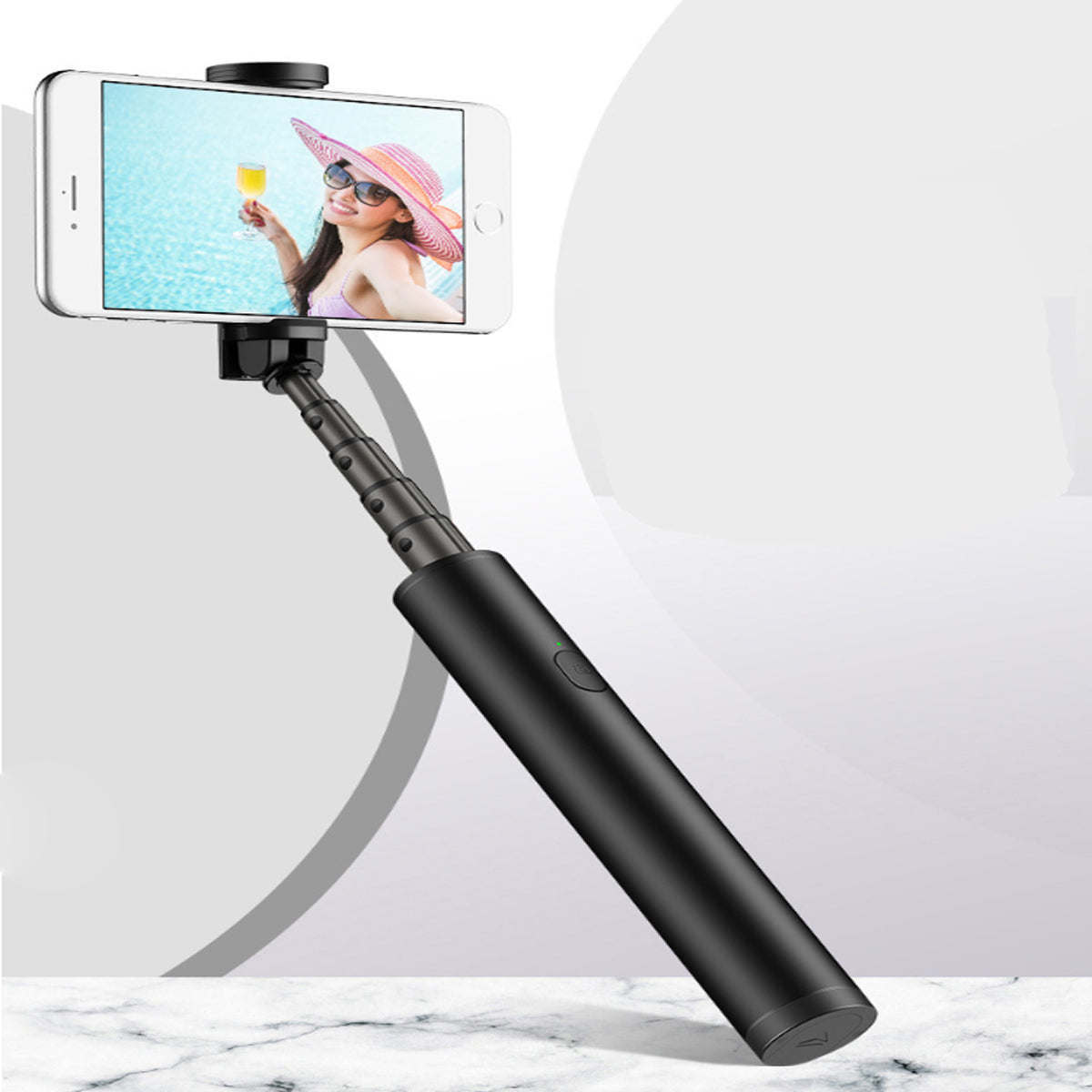 Black mini selfie stick extended, holding a smartphone.