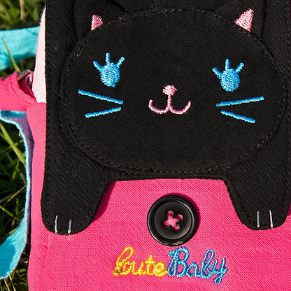 Embroidered cat face applique on black flap with pink panel and round snap button.
