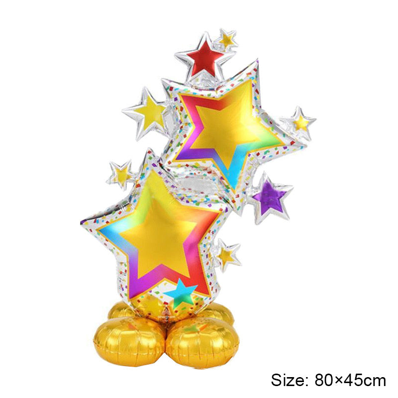 Rainbow star foil balloon decoration with gold star center and silver star accents on gold base.
