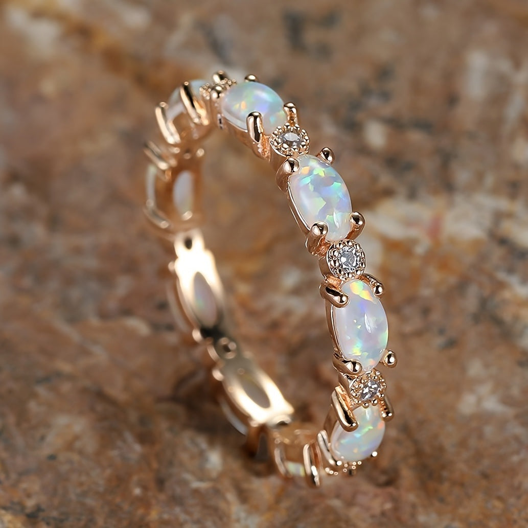 Gold-tone opal-style oval ring with bezel-set stones and small round clear accents
