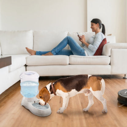 Pet water dispenser with clear barrel and speckled gray base; dog drinking from bowl
