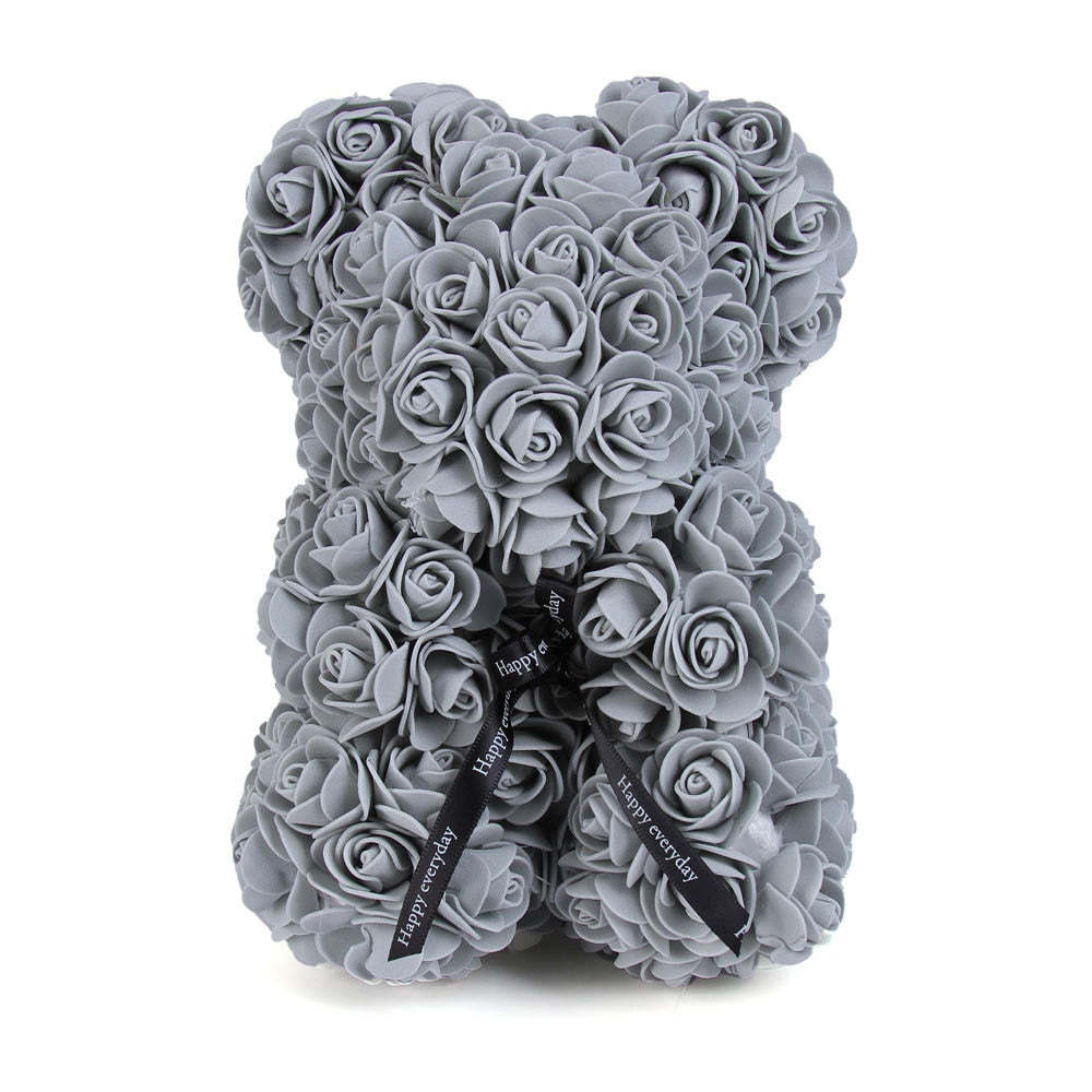 Gray rose teddy bear with layered rose petals and a black ribbon bow at the center