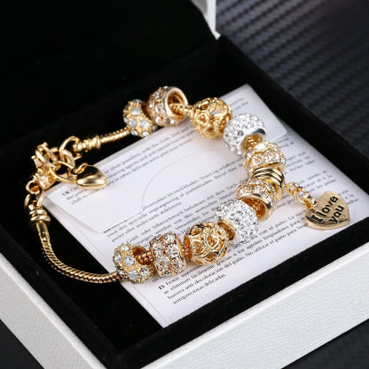 Gold plated heart charm bracelet featuring crystal barrel beads and heart tag