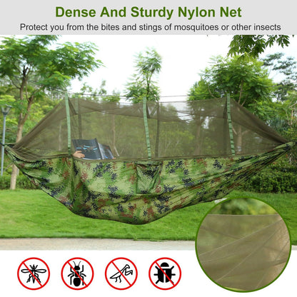 Green camouflage hammock with mosquito net stretched between trees