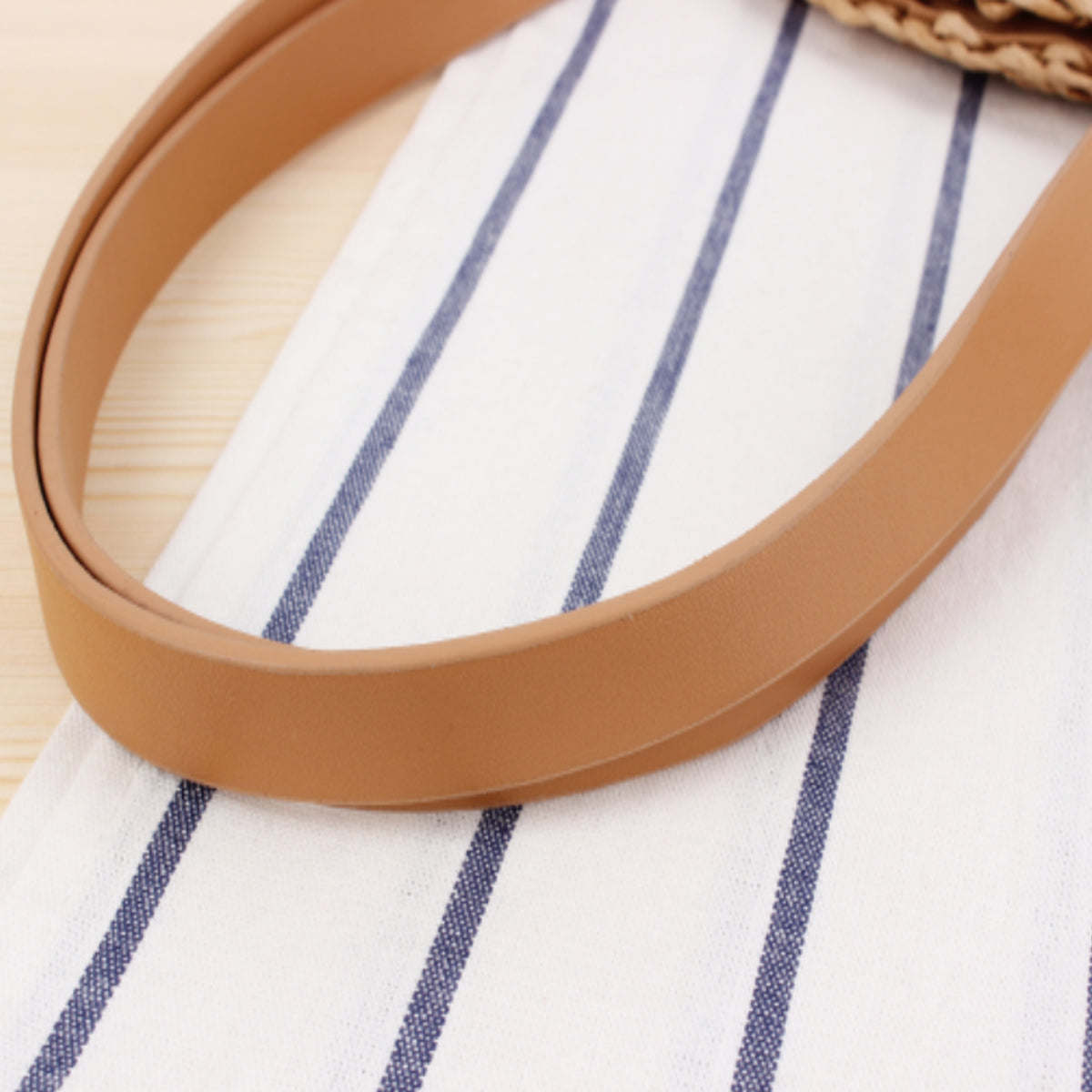 Tan tote bag interior with braided straw rim and blue striped cotton lining