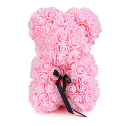 Light pink rose teddy bear with black bow ribbon tied at the neck
