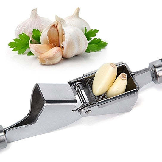 Stainless steel garlic press with garlic cloves in the open crushing chamber.