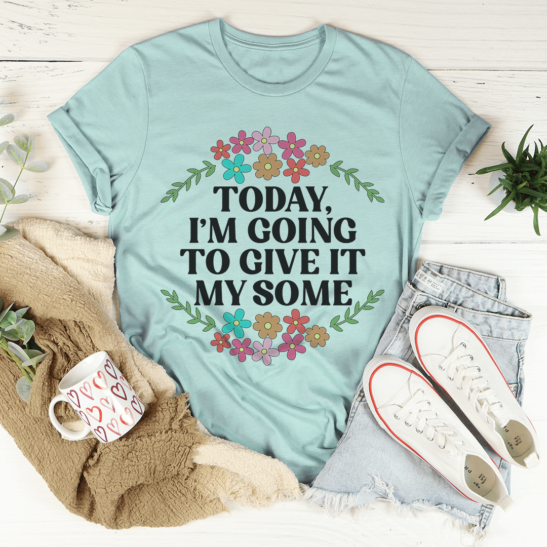 Teal graphic T-shirt with floral wreath and bold slogan print centered on the chest