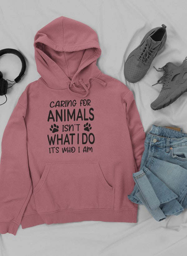 Pink hoodie with kangaroo pocket, drawstring hood, and animal care slogan graphic.