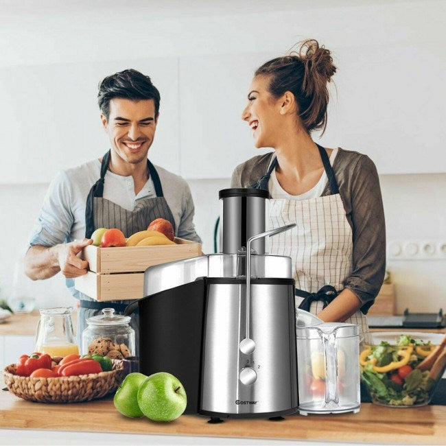 Electric centrifugal juice extractor on kitchen counter with clear juice cup and feeding tube
