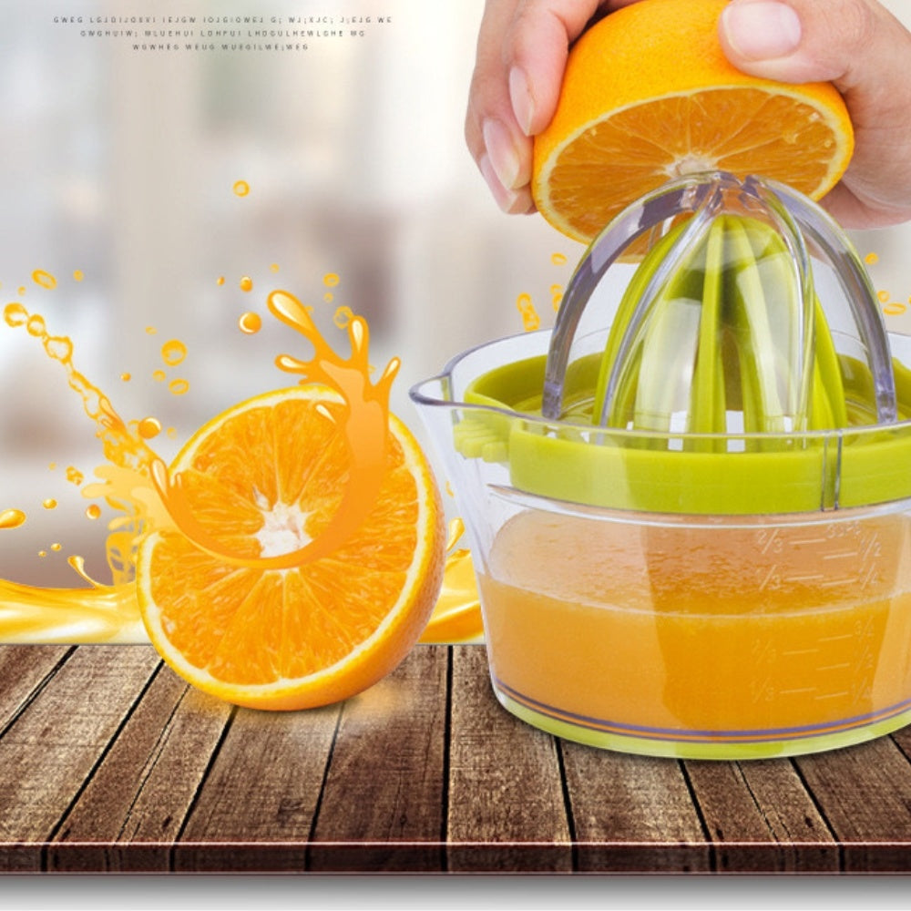 Green manual citrus squeezer pouring juice from the cone into the measuring cup.