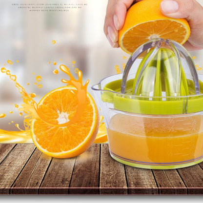 Green manual citrus squeezer pouring juice from the cone into the measuring cup.