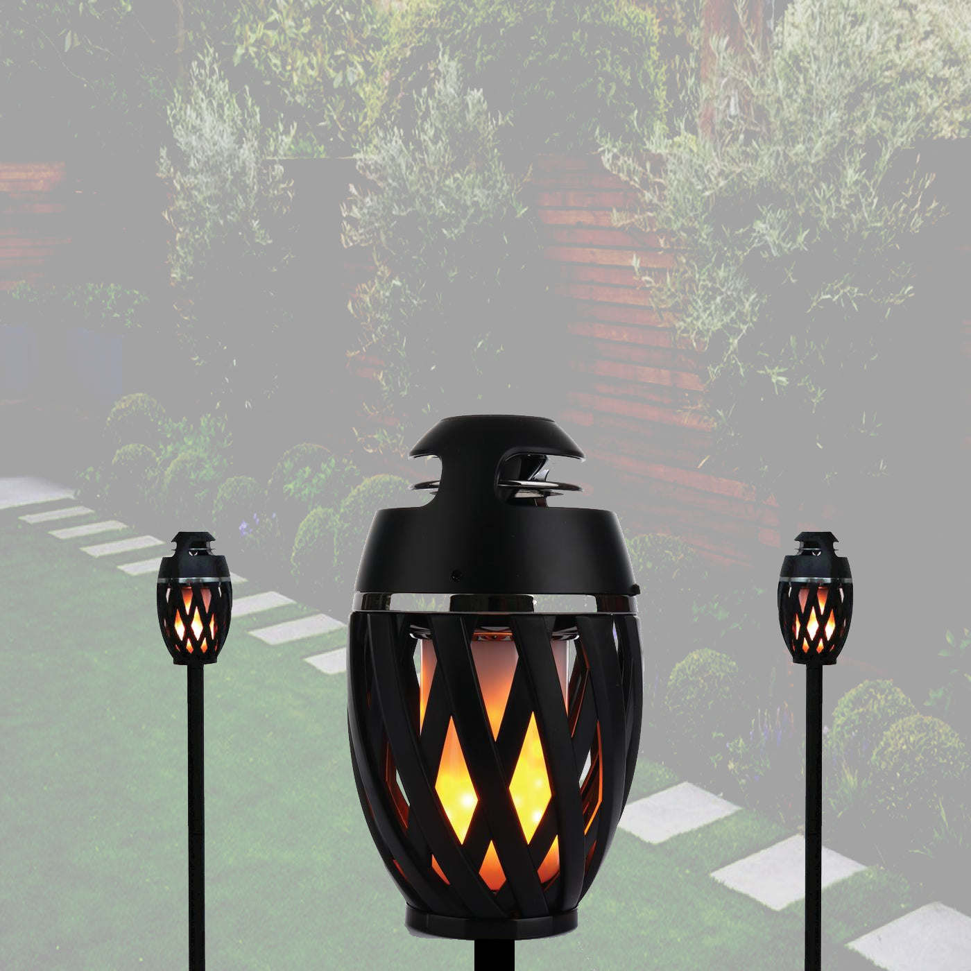 Outdoor LED torch light, large black flame lantern on ground, glowing amber pattern.