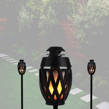 Outdoor LED torch light, large black flame lantern on ground, glowing amber pattern.