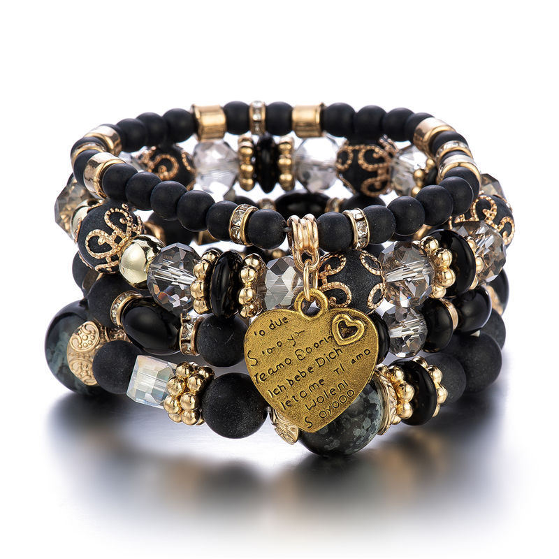 Layered charm bracelet set with black beads, gold accents, and heart pendant