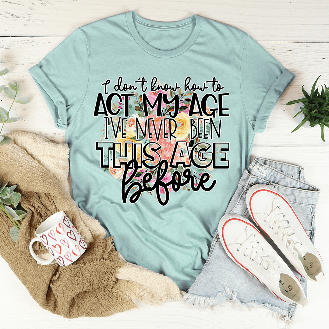 Dusty blue crewneck graphic T-shirt with 'act my age' slogan in bold script