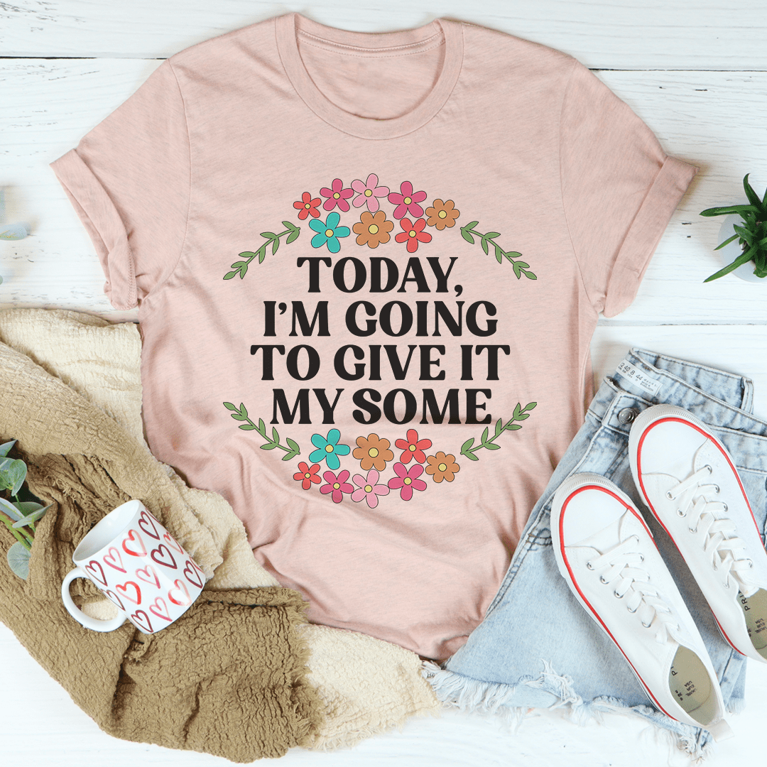 Heather pink graphic T-shirt with floral wreath and bold slogan print at center