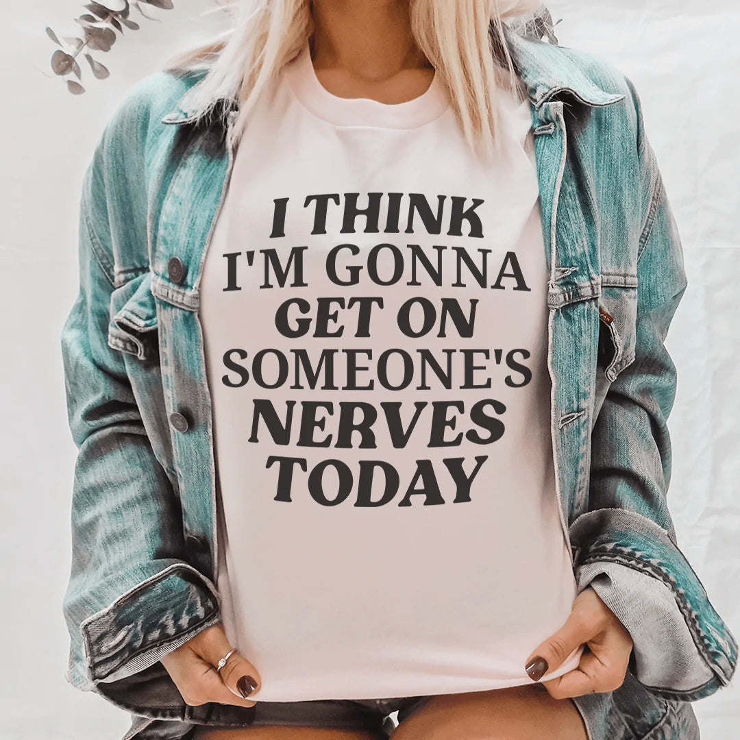 White crew-neck T-shirt with black quote text worn under a denim jacket.