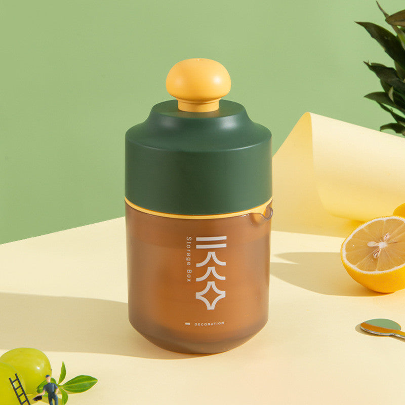 Portable manual citrus juicer with yellow squeeze top and green-brown container
