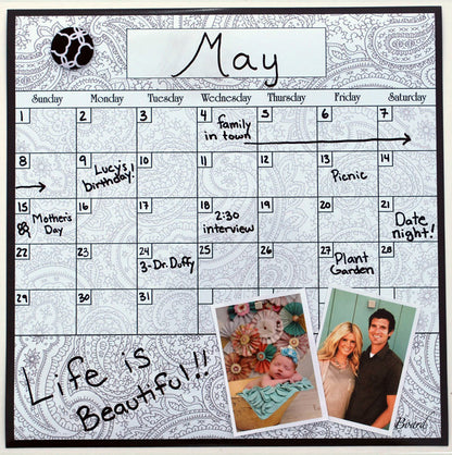 Dry erase calendar board with framed white grid and 'May' month header, paisley border