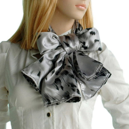 Silk scarf with black leopard print tied as a bow at the neck