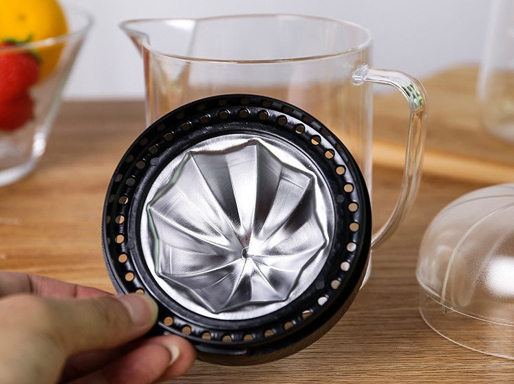 Close-up of black citrus strainer base with stainless metal reamer insert inside clear jug
