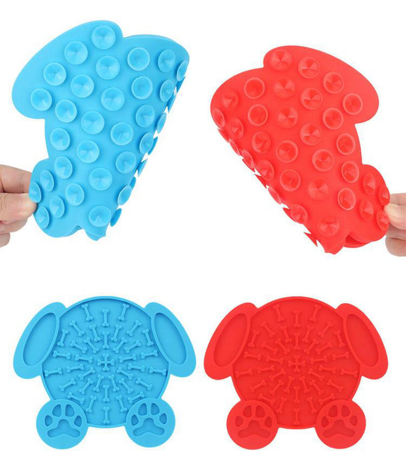 Blue and red bone-shaped dog lick mats with paw-print feet and raised ridged texture