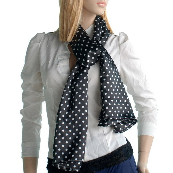 Black polka-dot silk scarf worn around neck, ends hanging
