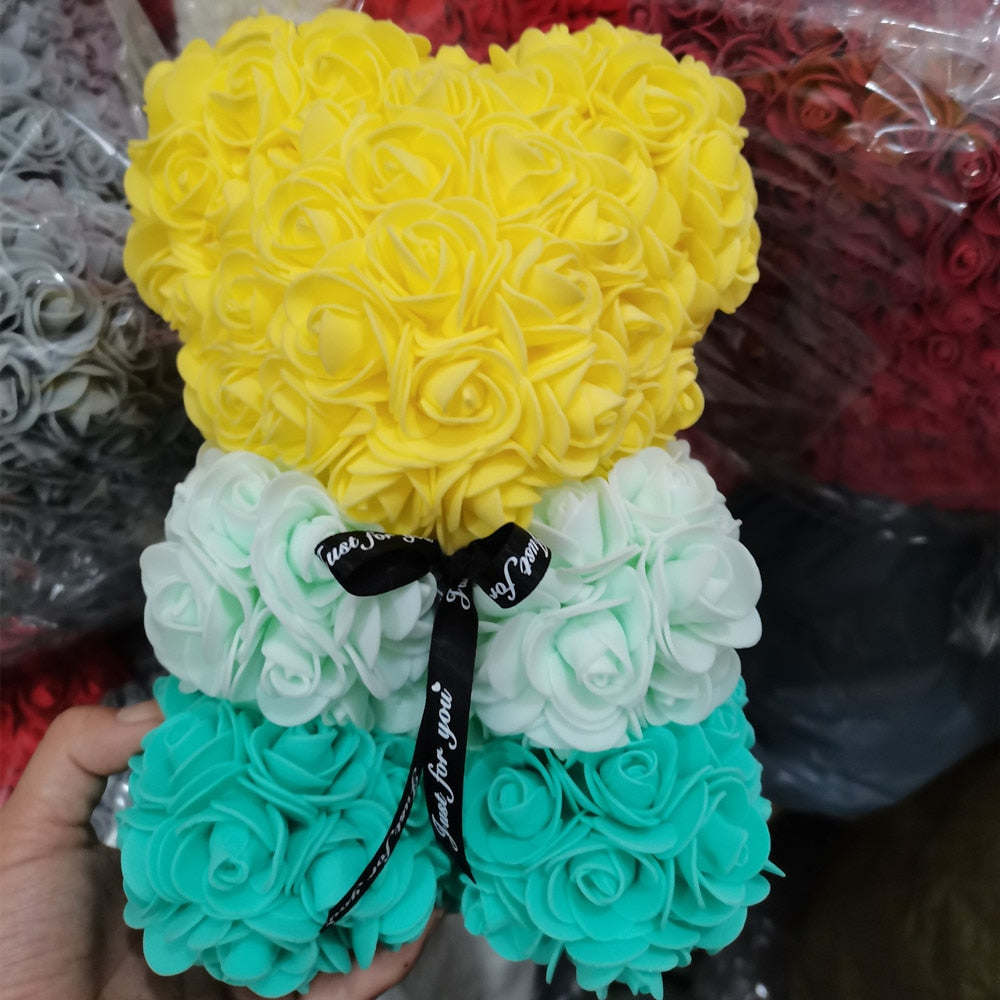 Multicolor rose teddy bear with yellow top, teal bottom, and black bow ribbon