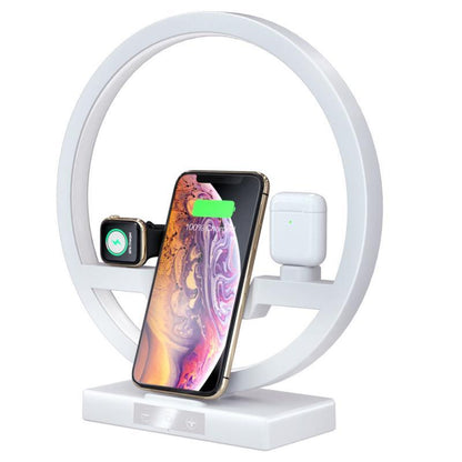 Wireless charger stand with white ring, smartphone, watch, and earbuds charging pads