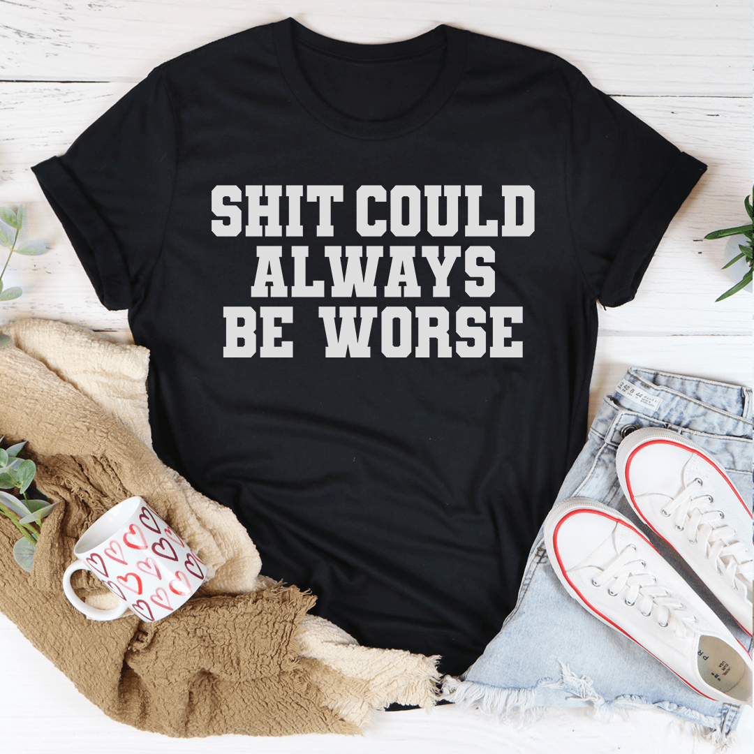 Black crewneck T-shirt with bold slogan text: 'SHIT COULD ALWAYS BE WORSE'