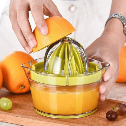 Green manual citrus squeezer with glass bowl, cone juicer, and measuring cup base.