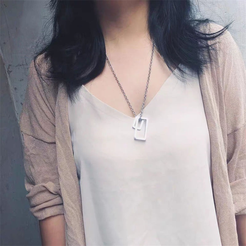 Silver geometric double-rectangle pendant necklace worn at the neckline
