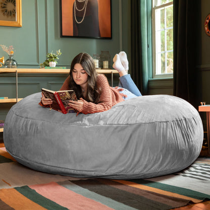 Large bean bag chair in gray, rounded seat with person reading while seated