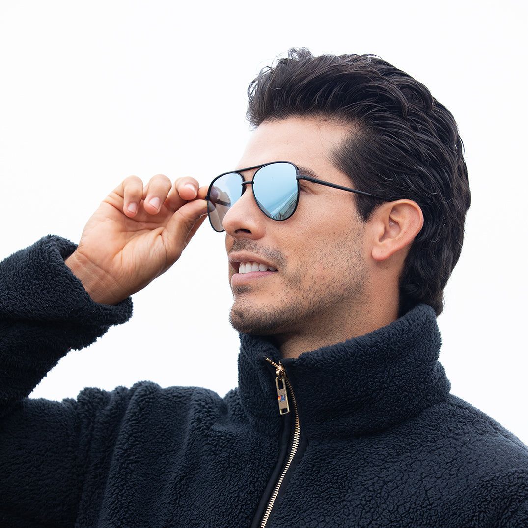 Polarized sunglasses on dark frames with blue mirrored lenses, held to face