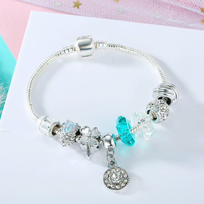 Silver charm bracelet with blue crystal and clear beads, angel and heart charm