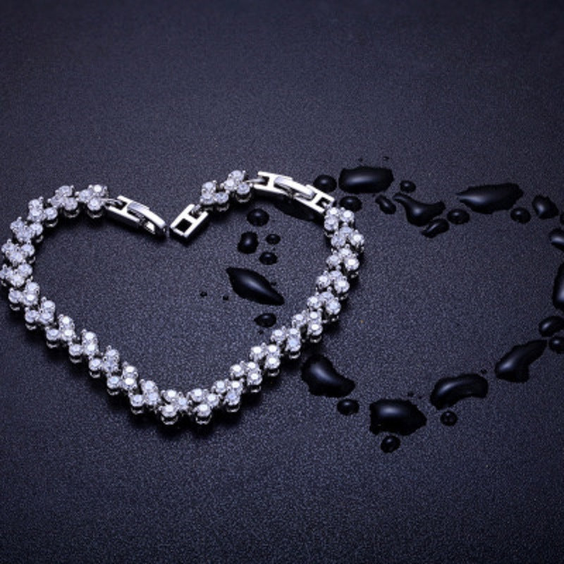 Silver tennis bracelet with oval curve of round rhinestone stones and clasp