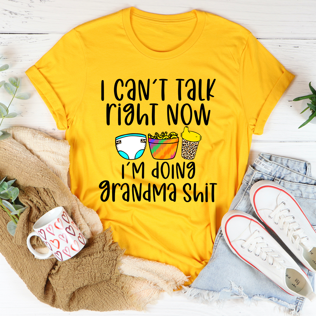 Gold crewneck T-shirt with “I can’t talk right now” text and colorful drink icons