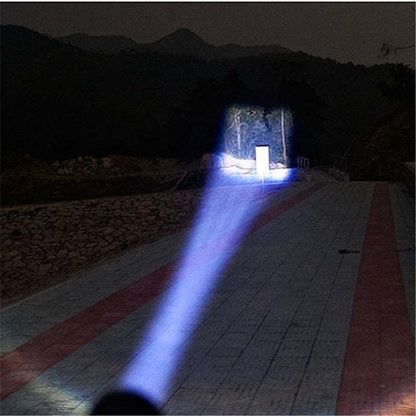 Zoomable flashlight casting a bright blue-white beam across a path at night