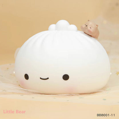White silicone dumpling night light with round face, raised cloud top, and pig figurine