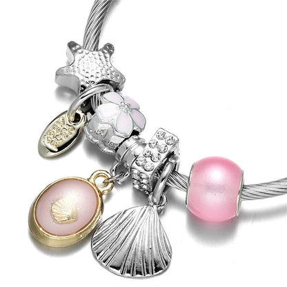 Silver wrap bangle bracelet with pink bead, flower, fan shell and oval charm