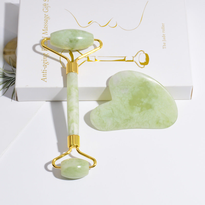 Jade roller tool set with green stones and gold-tone frame, shown on gift card