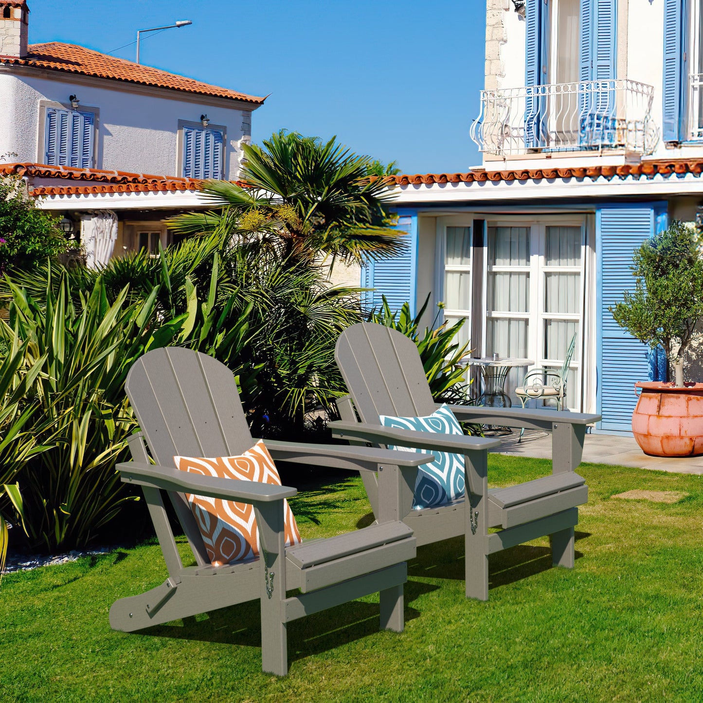 Pair of folding Adirondack-style patio chairs with slatted backs and seats on lawn.