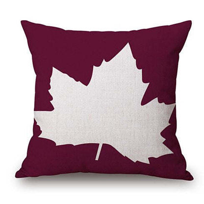 Wine cushion cover with white leaf cutout design and maroon frame.