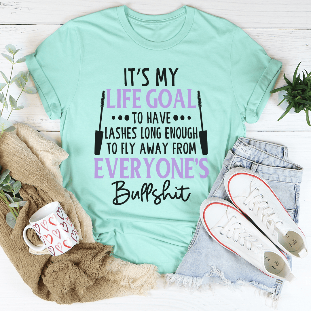 Mint green crew-neck T-shirt with purple/black quote graphic, 'It's my life goal'