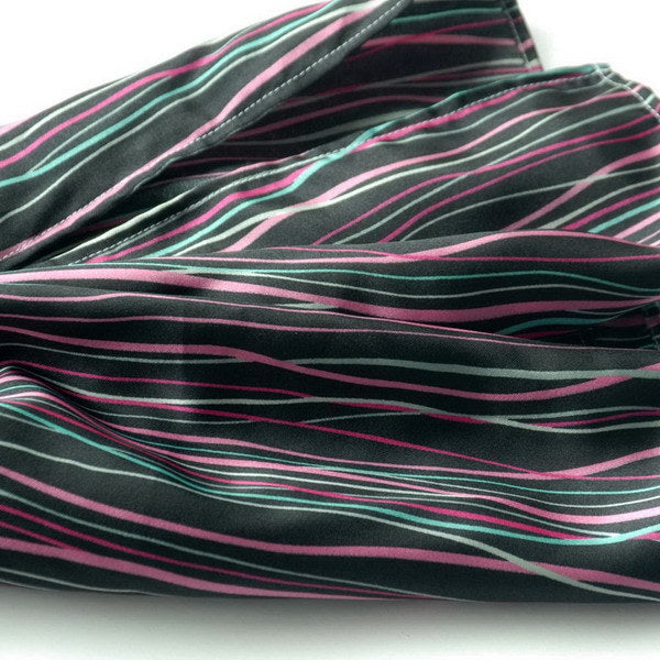 Silky scarf fabric with dark wavy horizontal stripes in pink and teal.