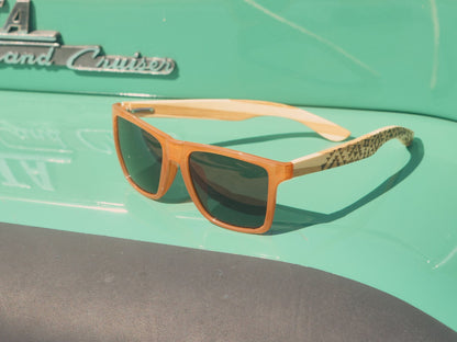 Polarized sunglasses with orange frames, dark lenses, and patterned temple arms