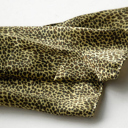 Leopard-print silk scarf detail, olive and tan scattered spots on soft fabric
