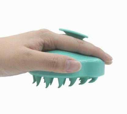 Teal silicone scalp massager brush shown from side, spike bristles on underside