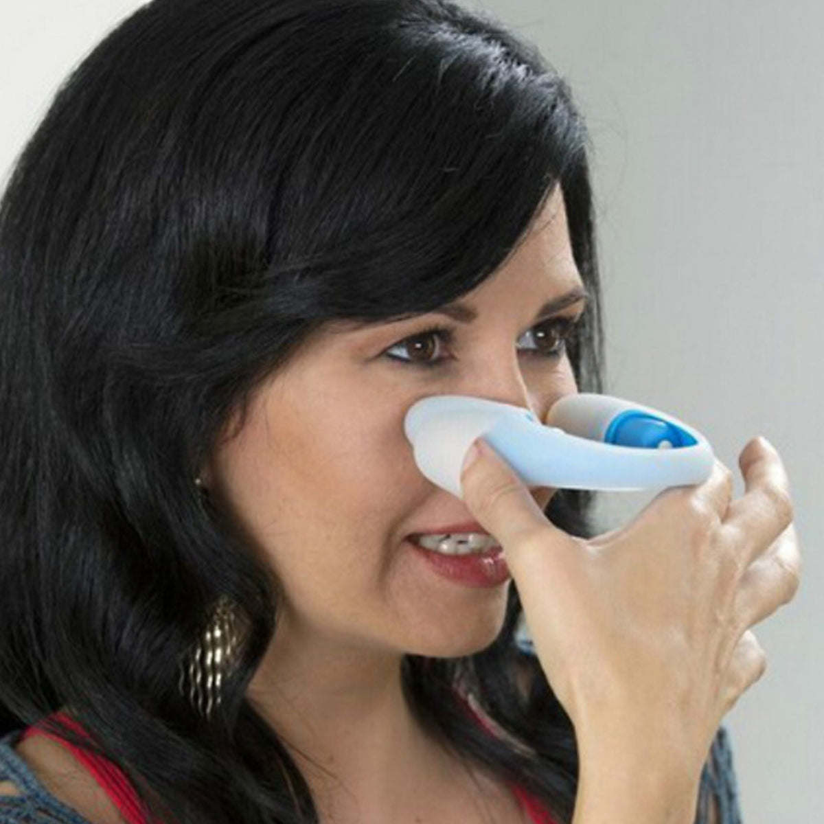 Eye massager in use: white pads on the under-eye area, blue handle ring